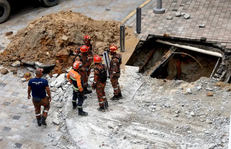 Indian woman falls into the sink hole after pavement collapses