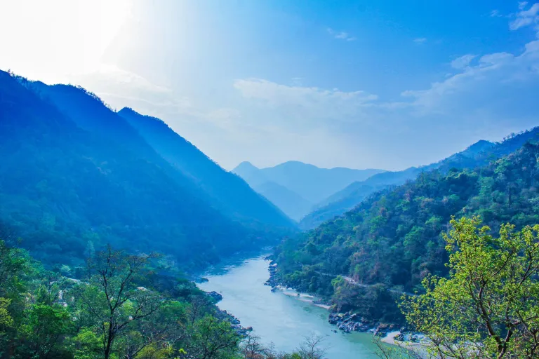 The Ganges flowing through Rishikesh with hills in the background.