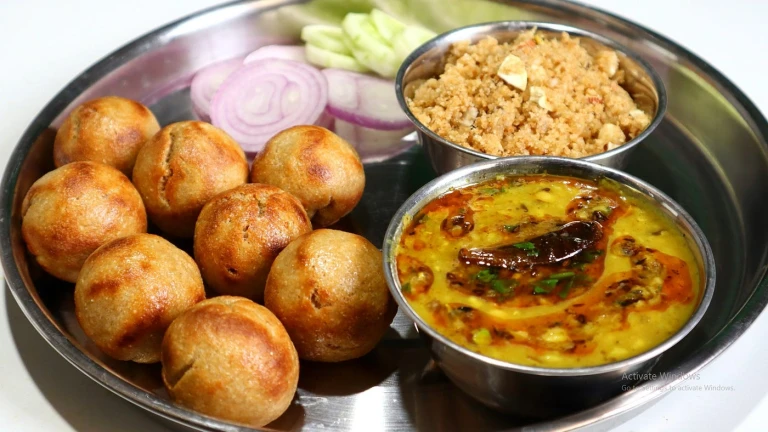 Dal Bati Churma: A Rajasthani delight of lentils, wheat rolls, sweet crumbs, and ghee.