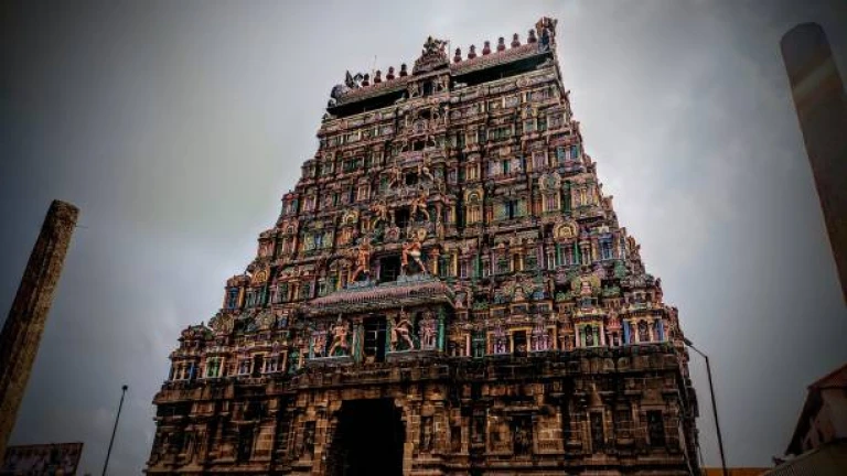 Pattiswarar Temple in Coimbatore, India, set against a dramatic cloudy sky.