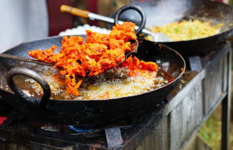 Close -up of Indian street vendor deep frying mutton in pan