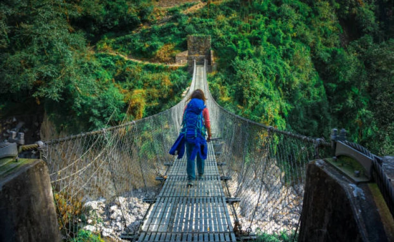 Young woman crossing suspension bridge 