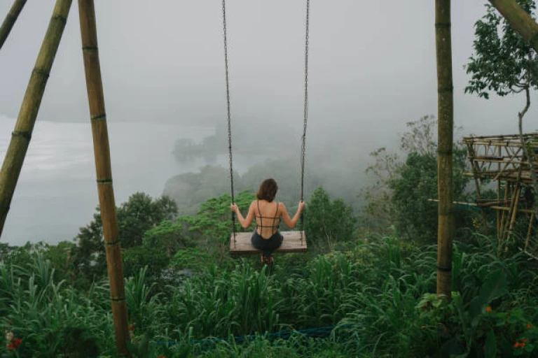 Woman on the swing over the jungles and lake in Bali 