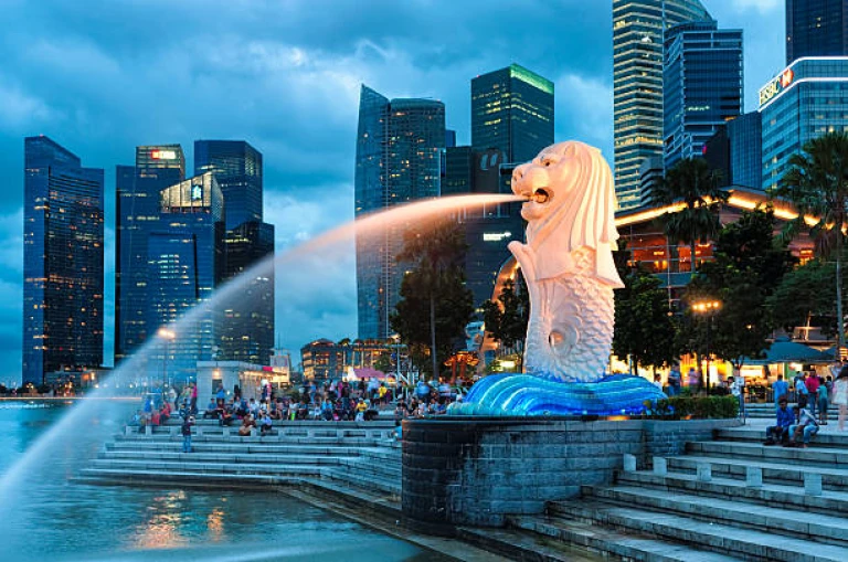 The Merlion fountain lit up at night in Singapore.