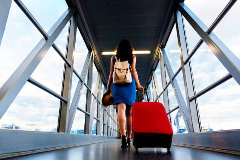 Young traveler walking with carrying hold suitcase in the airport