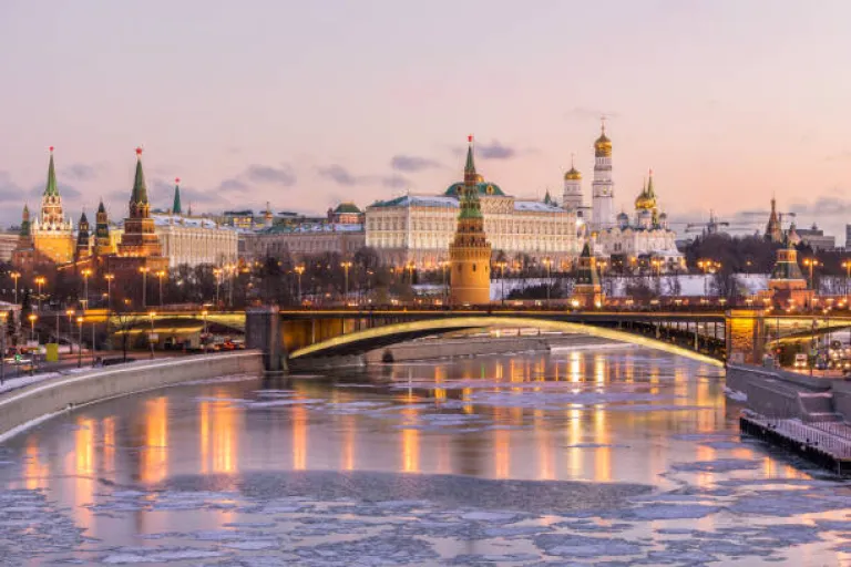 Moscow Kremlin and Moscow river in winter morning. Pinkish and golden sky with clouds. Russia