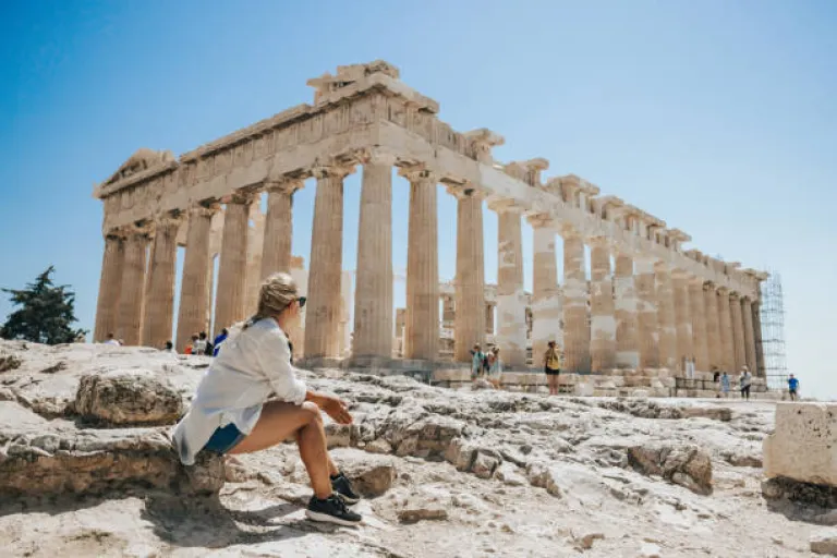 Woman relaxing while looking at Parthenon temple on a sunny day 